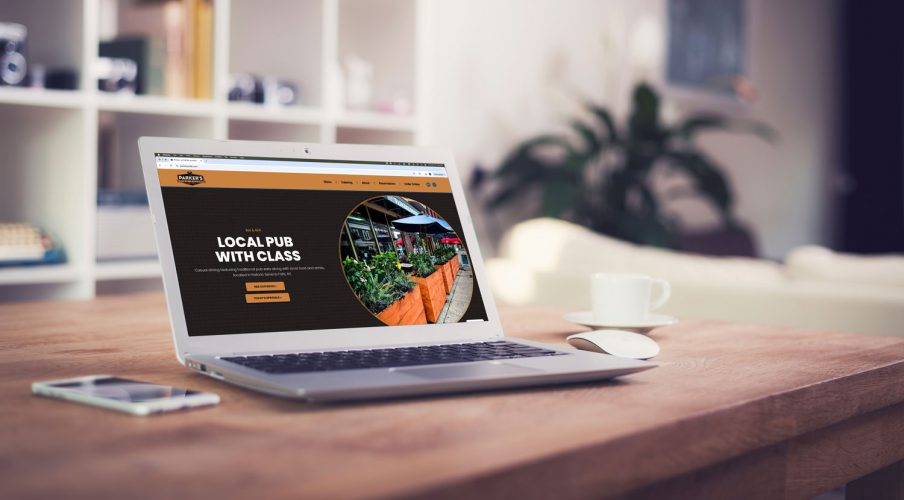 Custom website design shown on a laptop computer in an office